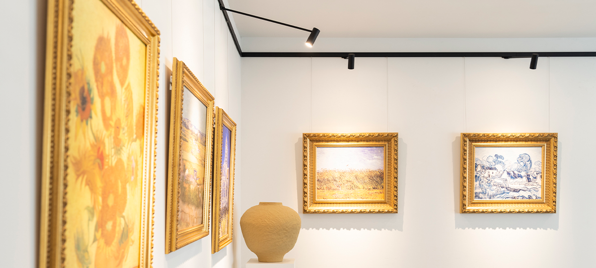 Kunstwerken in gouden lijsten opgehangen met professionele schilderijrails en ophangdraden in een museum