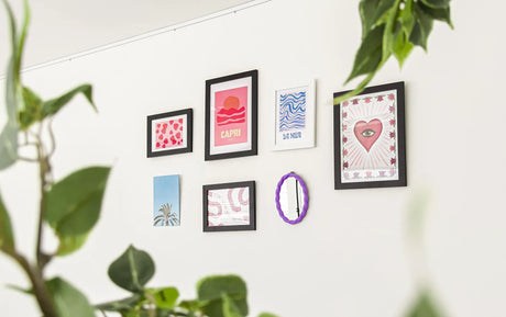 verschillende fotolijstjes aan wand