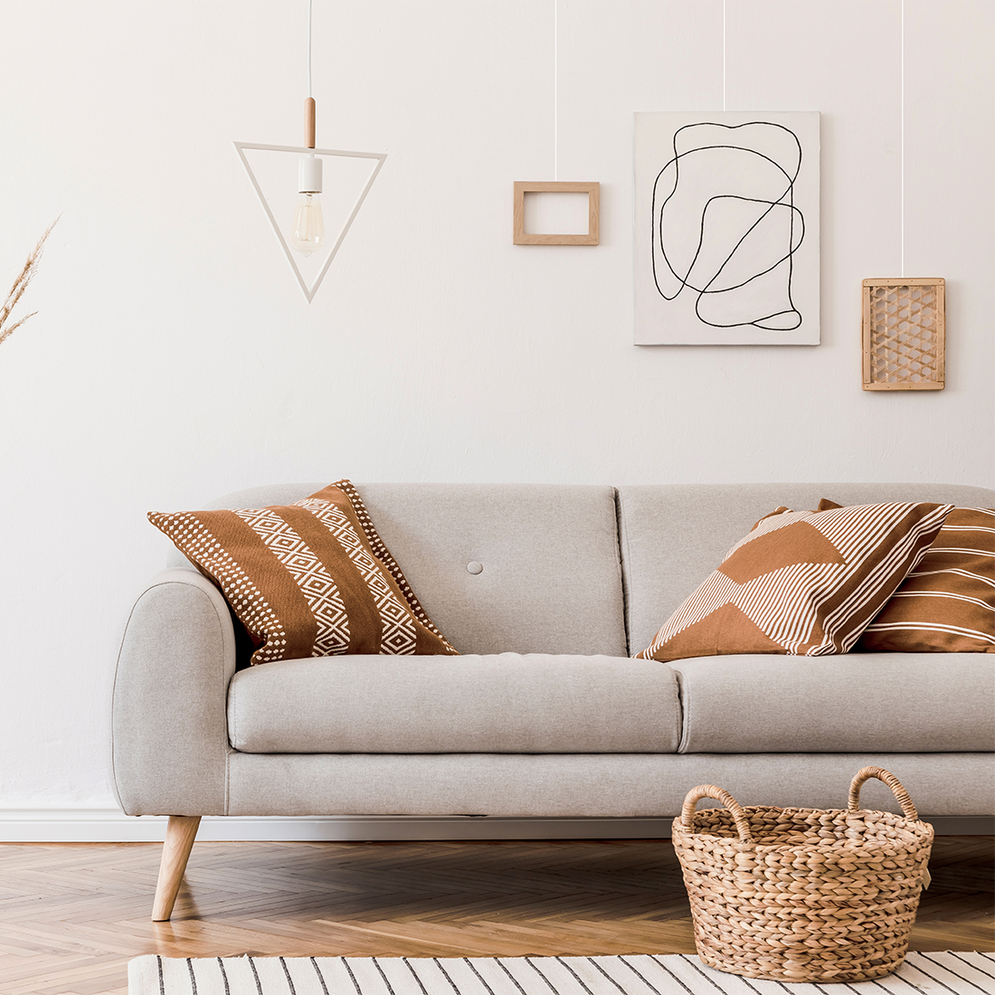 Witte muur grijze bank schilderijen aan rail