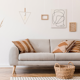 Witte muur grijze bank schilderijen aan rail