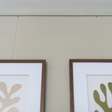 schilderijen aan ophangsysteem met twister ophangdraden